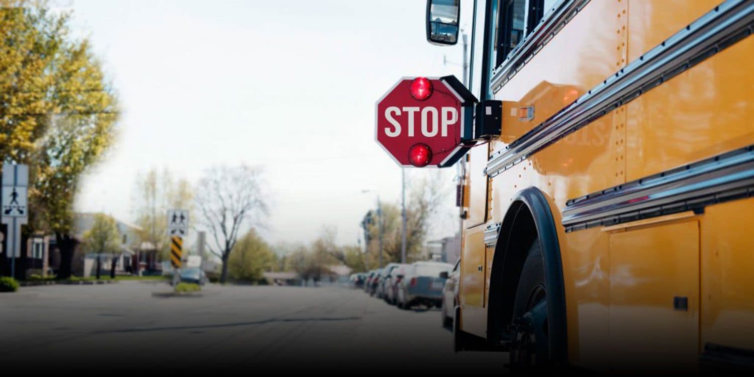 Yellow school bus stopped with its stop sign extended.